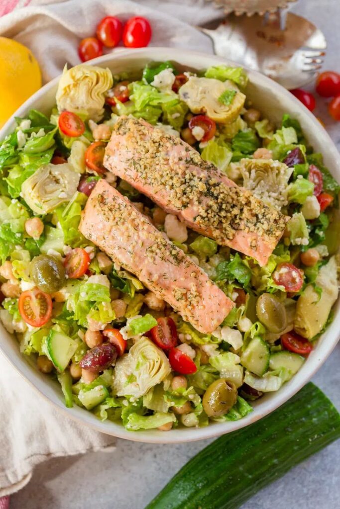 a bowl of salad with salmon and vegetables